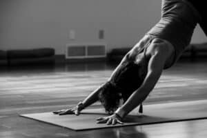 black and white photo of woman doing yoga pose downward dog