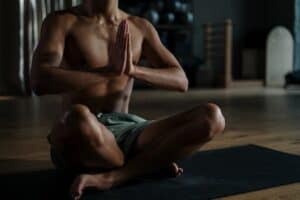 Man doing yoga with hands at chest sitting cross legged