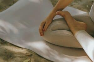 Calming yoga pose on a white mat outdoors, emphasizing mindfulness and stress relief.