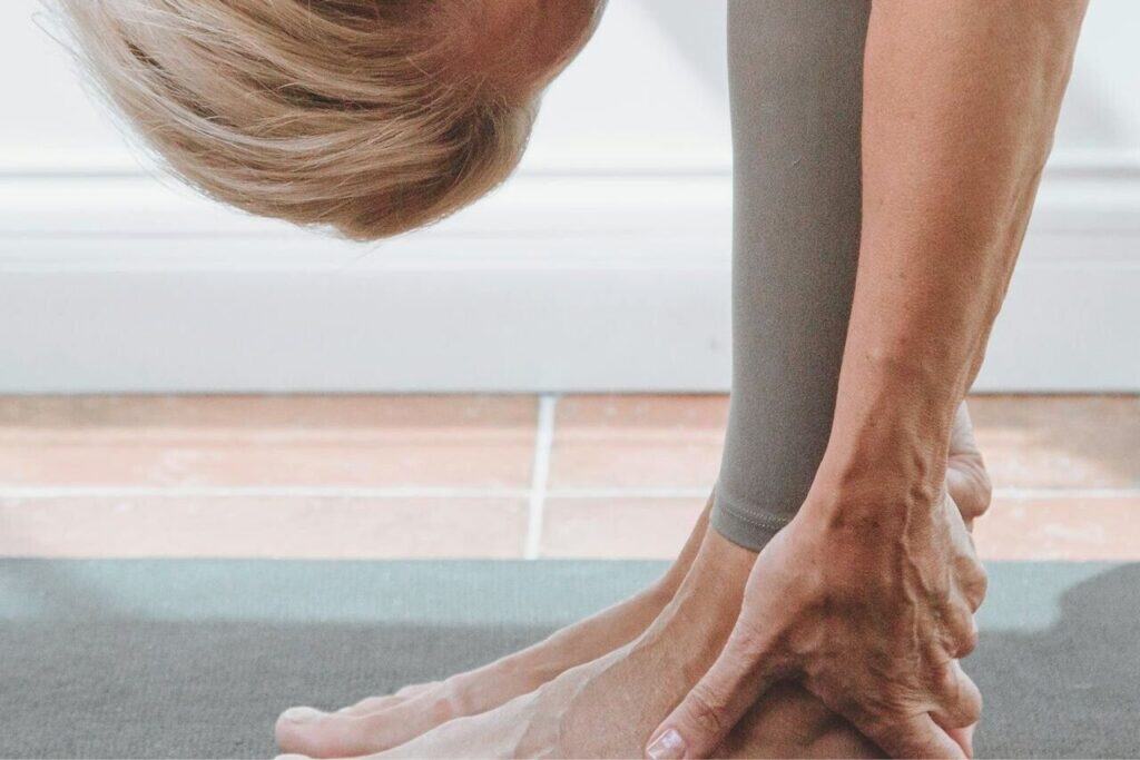 Relaxed woman practicing yoga or stretching on a mat, focusing on mindfulness and self-care, promoting mental clarity and physical flexibility.