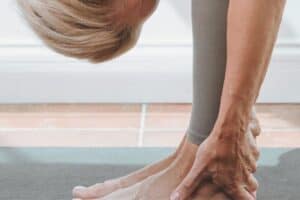 Relaxed woman practicing yoga or stretching on a mat, focusing on mindfulness and self-care, promoting mental clarity and physical flexibility.